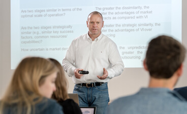 Lehrende an der Hochschule der Bayerischen Wirtschaft - Professor vor Whiteboard